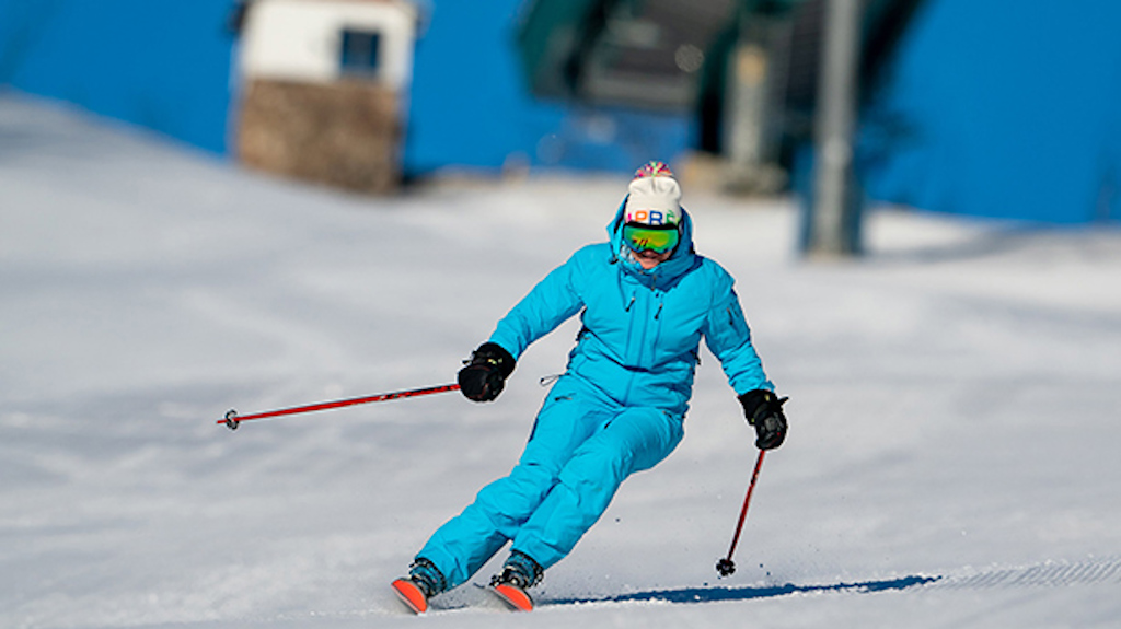 A woman wearing bright blue, making turns on a sunny day. 
